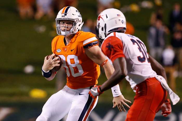 Virginia Cavaliers quarterback Brennan Armstrong (98) runs with the ball as Richmond Spiders defensive back Devon Perry (30) defends during the second half at Scott Stadium.